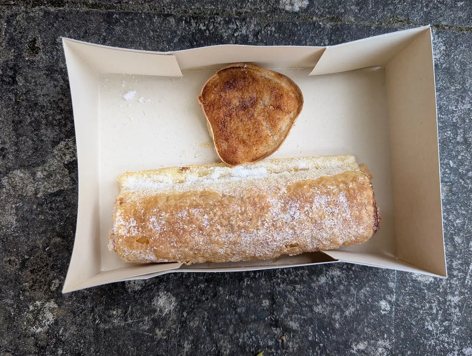 Two pastries in a bakery takeout box, photographed in Portugal.