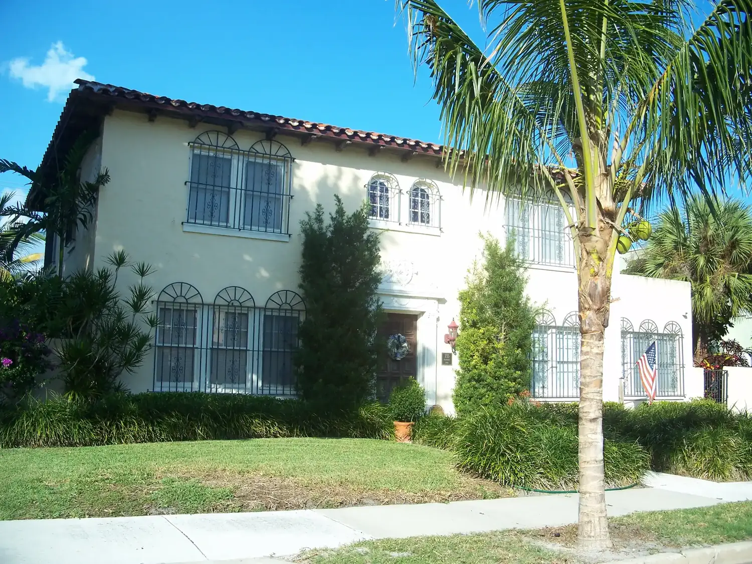 A two-story stucco house with a red tile roof in the El Cid Historic District of West Palm Beach.