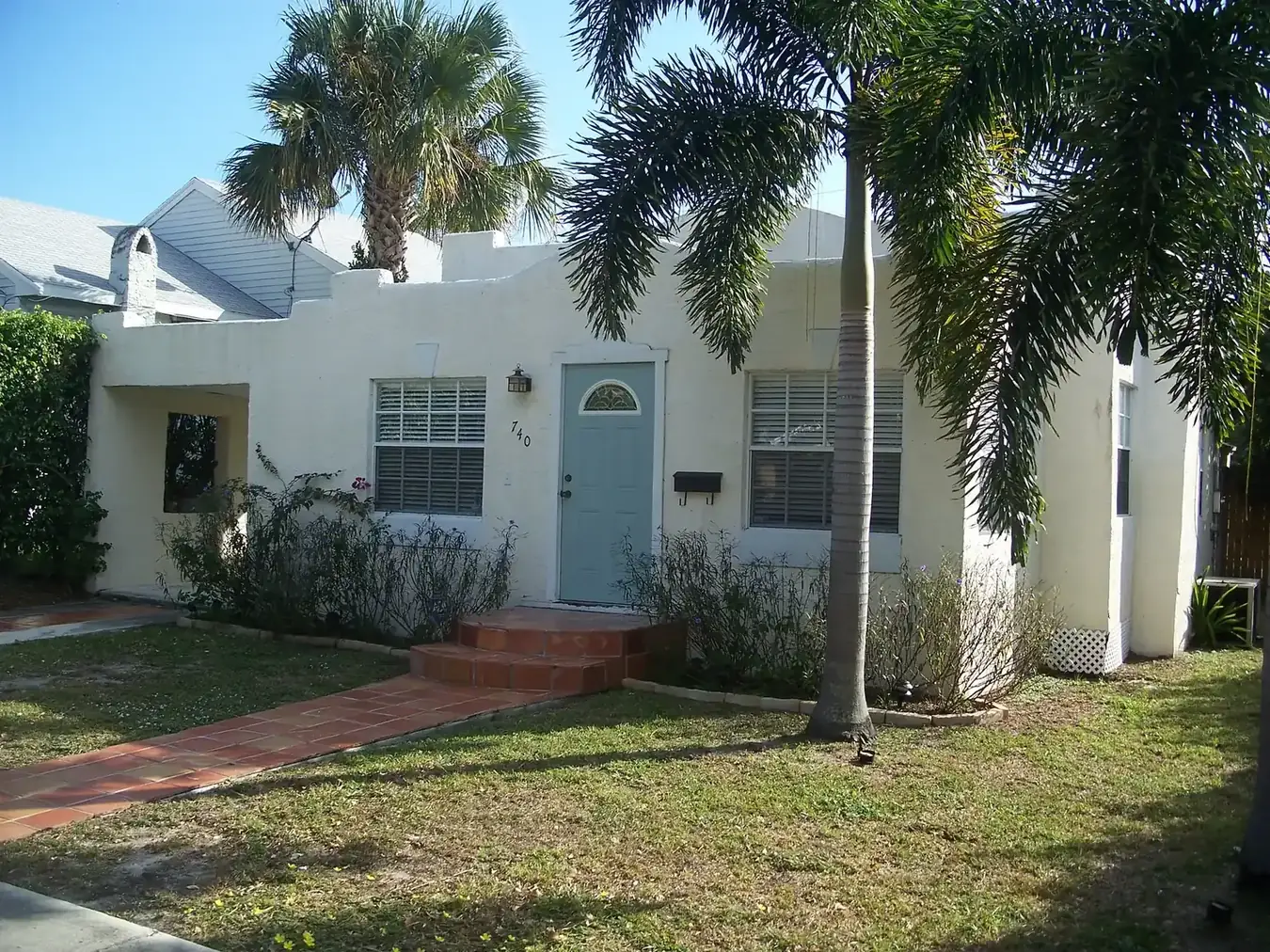 A white stucco house with a blue door in the Grandview Heights Historic District of West Palm Beach.