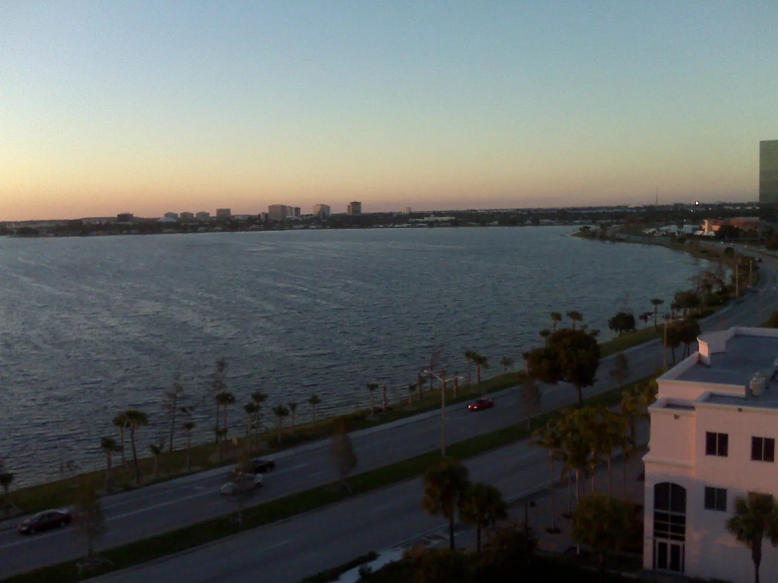 Clear Lake and the road along its shore in West Palm Beach at dusk, where the Clear Lake Trail runs.